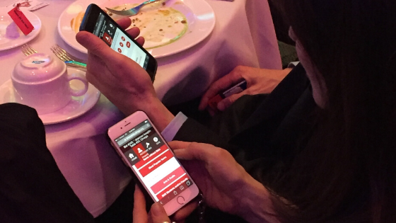 people at an auction on their phone